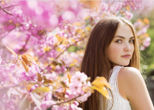 a woman standing in front of a flower