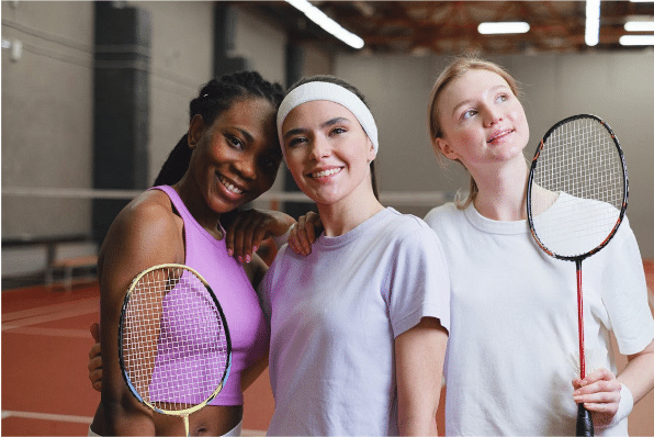 a man and woman posing for a picture while holding a racket